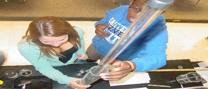 Anna Hall and Issaac Marshall record data from the apparatus